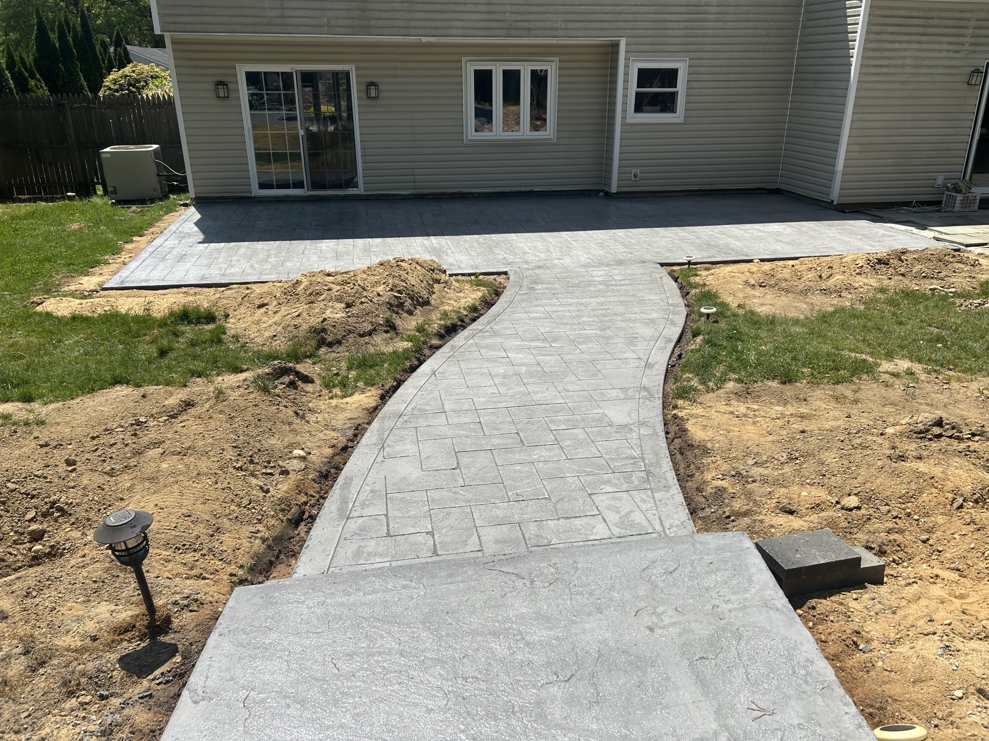 Winding stamped walkway connecting patio and yard