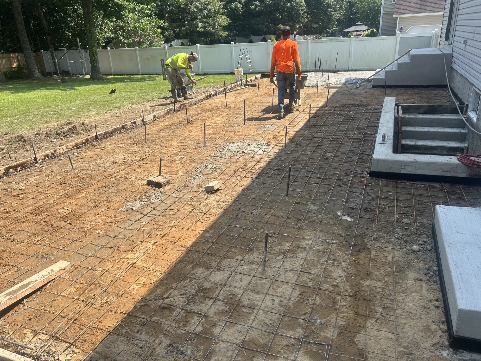 Crew setting wire mesh for large patio pour