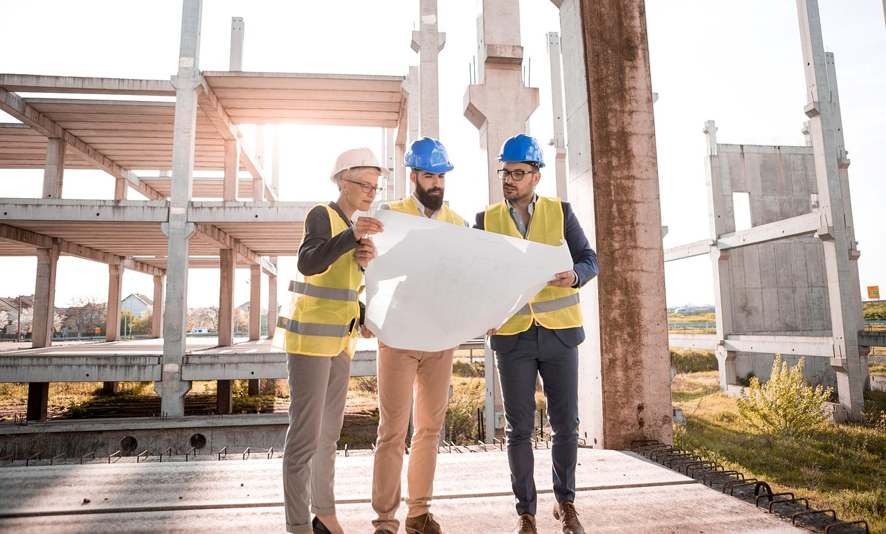 Construction consultants reviewing blueprints on site